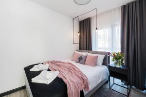 a bedroom with a bed with pink pillows and a mirror at Esti Apartament nad Jeziorem Czorsztyńskim in Czorsztyn