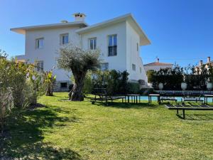 a large white building with picnic tables in the grass at Villa Louise-Rose in Villeneuve-Loubet