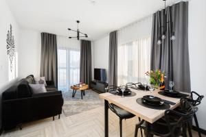 uma sala de estar com uma mesa e cadeiras e um sofá em Esti Apartament nad Jeziorem Czorsztyńskim em Czorsztyn