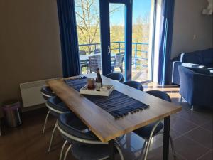 a dining room table with a bottle of wine and chairs at Enjoy Durbuy 1 in Durbuy