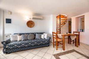 a living room with a blue couch and a table at Villa by Hotel Thira in Fira