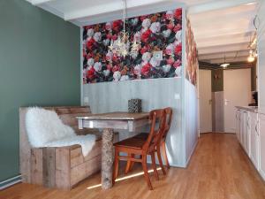 ein Esszimmer mit einem Tisch und einem Gemälde an der Wand in der Unterkunft Chalet Hoenderloo Den in Hoenderloo
