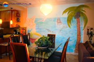 佩納斯科港的住宿－Marina Pinacate B-405，墙上挂着棕榈树画的用餐室