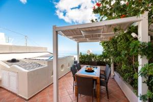 a patio with a table and chairs and a hot tub at Villa by Hotel Thira in Fira