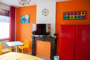 a living room with orange walls and a red cabinet at Vip room 209 in Trooz