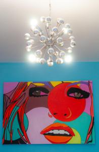 una lámpara de araña con una pintura de una mujer en Vip room 209, en Trooz