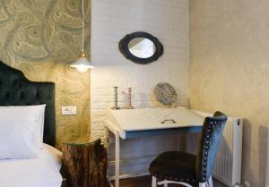 Schlafzimmer mit einem Bett, einem Schreibtisch und einem Stuhl in der Unterkunft Restauro Apartament in Buzău
