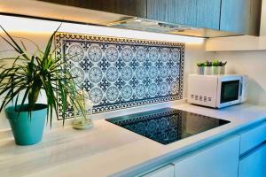 a kitchen with a microwave and a plant on a counter at Casa de diseño 200m Mezquita 2 rooms & 2 bathrooms in Córdoba