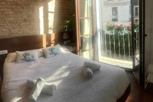 a bed with two towels on it with a window at Casa de diseño 200m Mezquita 2 rooms & 2 bathrooms in Córdoba