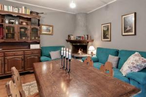 een woonkamer met een tafel, een bank en een open haard bij Dagli Olivari - Casa Ale in Gromo