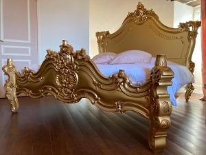 un letto decorato in una camera da letto con struttura dorata di Château de la Preuille Bed & Breakfast a Montaigu-Vendée