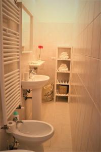 Baño blanco con lavabo y aseo en Nunuccio - Locazione Turistica, en Polignano a Mare