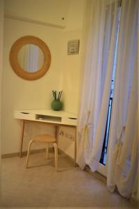 escritorio con silla junto a una ventana con cortinas en Nunuccio - Locazione Turistica, en Polignano a Mare