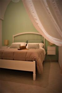 1 dormitorio con 1 cama con dosel blanco en Nunuccio - Locazione Turistica, en Polignano a Mare