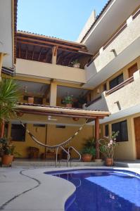 a swimming pool in front of a building at Casa Celeste Hotel in Zihuatanejo