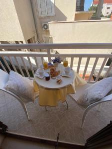 a table with food and drinks on a balcony at Viola Cavtat Rooms in Cavtat