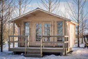 a wooden cabin with a porch in the snow at Rauðuskriður farm in Hólmabæir