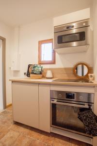 a kitchen with a stove and a microwave at Loft Terrasse, l'Hauture, Arles in Arles