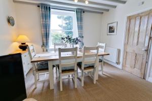 een eetkamer met een tafel en stoelen en een raam bij Bryn Mel Honey Hill Cottage in Llangoed