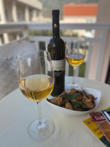 a glass of white wine and a bowl of food at Viola Cavtat Rooms in Cavtat +26 photos