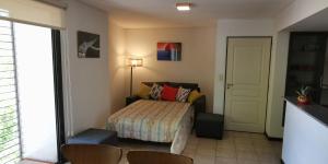 a bedroom with a bed and a table and chairs at Belgrano Apartment con cochera in Mendoza