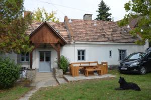 a house with a picnic table and a dog sitting in the yard at A la maison - épp mint otthon in Szentbékkálla