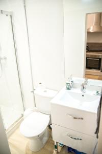 a white bathroom with a toilet and a sink at La jungle Nantaise in Nantes