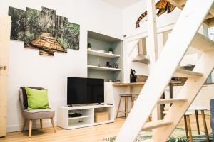 a living room with a television and a staircase at La jungle Nantaise in Nantes