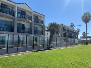 ein Gebäude mit einem Zaun und Palmen in der Unterkunft Ocean Park Inn in San Diego