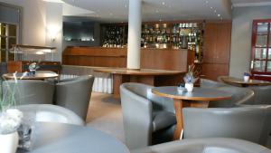 a restaurant with tables and chairs and a bar at Hotel ABBEY in Grimbergen