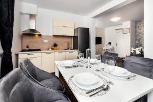 a dining room with a white table and chairs at Deluxe Apartments A&A in Rovinj