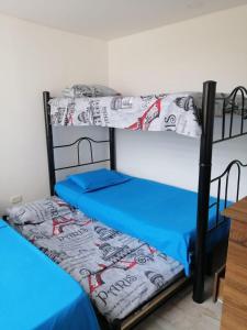 2 beliches num quarto com lençóis azuis em Apartamento familiar para un buen descanso con WiFi em Ricaurte