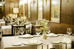 un comedor con mesas con manteles blancos y copas de vino en Hotel Conde Rodrigo 2, en Ciudad Rodrigo