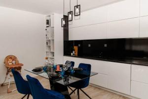 uma sala de jantar com uma mesa preta e cadeiras azuis em Super luxurious & spacious designer apartment. em Stara Zagora