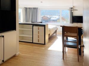 um quarto com uma secretária, uma cama e uma janela em Grüezi Laax Apartments em Laax