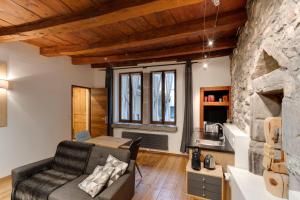 salon z kanapą i kamienną ścianą w obiekcie La Cour Filaterie - Suite au cœur d'Annecy w Annecy