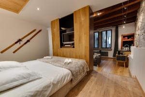 sypialnia z dużym łóżkiem i telewizorem w obiekcie La Cour Filaterie - Suite au cœur d'Annecy w Annecy