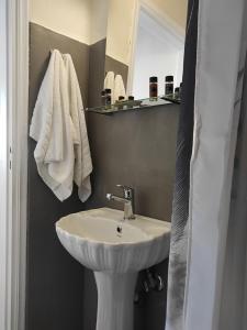 a bathroom with a white sink and a mirror at Budget Studio 2 - renovated January 2020 in Haraki