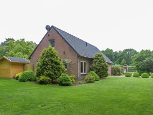 een rood bakstenen huis met een groene tuin bij Rural holiday home in Vessem with a sauna in Vessem