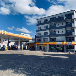 a large building in front of a gas station at Hotel Santa Terezinha in Alfredo Chaves