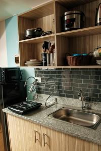 eine Küche mit einer Spüle und einer Arbeitsplatte in der Unterkunft Laurens Crib Staycation in Marilao FREE Parking & WIFI in Marilao