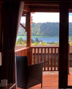 a balcony with a view of the water at BUYAN LODGE lake view villa in Bedugul