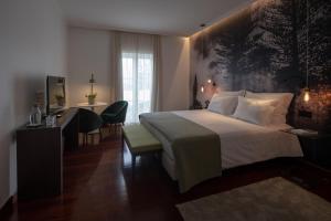 a hotel room with a large bed and a desk at Senhora da Rosa, Tradition & Nature Hotel in Ponta Delgada