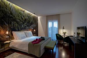 a bedroom with a bed with a large painting on the wall at Senhora da Rosa, Tradition & Nature Hotel in Ponta Delgada