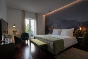 a bedroom with a bed and a table and a window at Senhora da Rosa, Tradition & Nature Hotel in Ponta Delgada