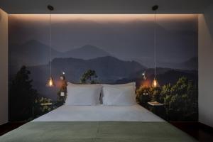 a bedroom with a bed with mountains in the background at Senhora da Rosa, Tradition & Nature Hotel in Ponta Delgada