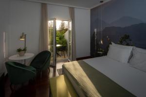 a hotel room with a bed and a table and chairs at Senhora da Rosa, Tradition & Nature Hotel in Ponta Delgada