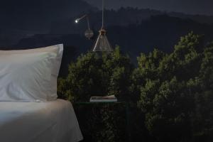 a bedroom with a bed and a lamp and trees at Senhora da Rosa, Tradition & Nature Hotel in Ponta Delgada