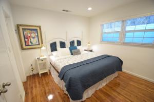 a bedroom with a large bed with a blue blanket at Venice Beach Apartments Monthly rents in Los Angeles