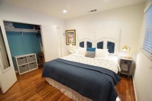 a bedroom with a large bed with blue and white sheets at Venice Beach Apartments Monthly rents in Los Angeles